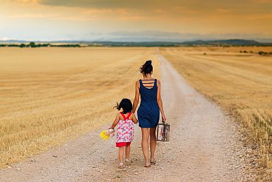 girl and woman walking down dirt road