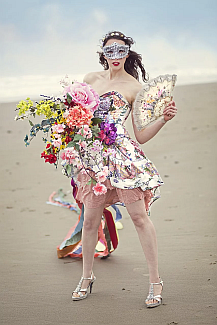 immagine di una donna con fiori che indossa una maschera sulla spiaggia